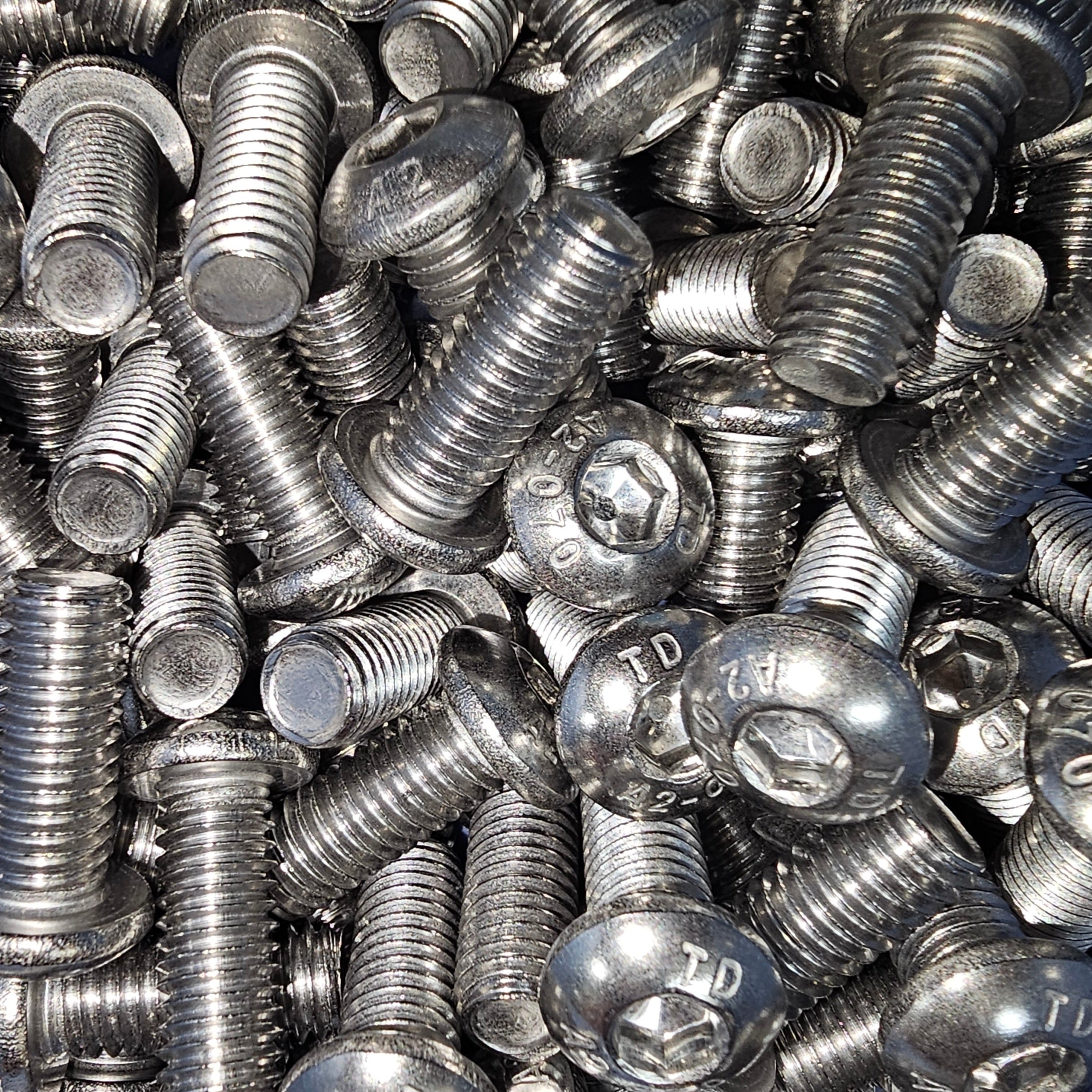 Stainless steel A2-70 button socket screws with hex drive, shown in a close-up image, designed for durable fastening applications.